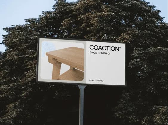 A roadside billboard reading COACTION® SHOE BENCH 01 in front of trees, on paper