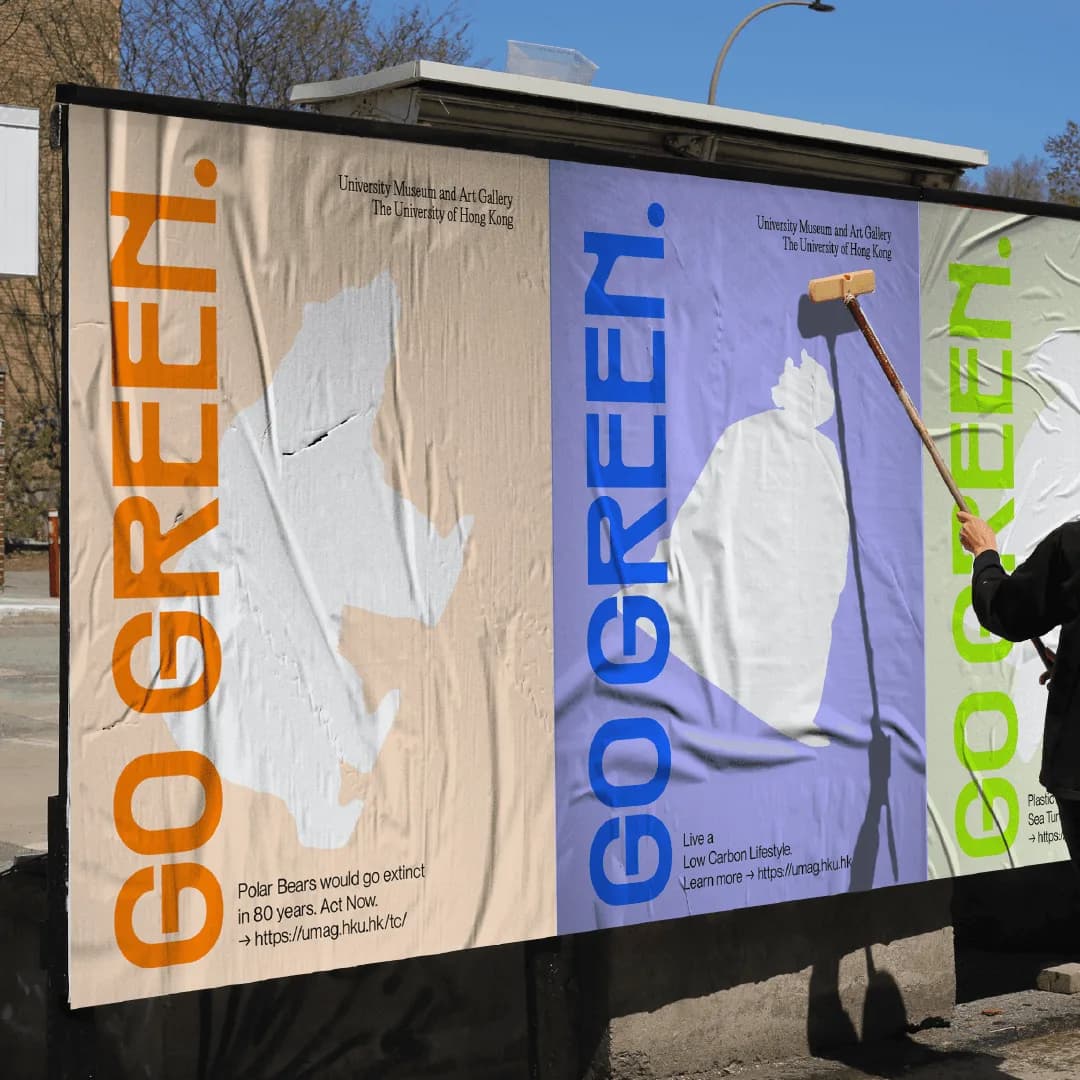 A worker wheat-pasting a blue GO GREEN. poster onto a street billboard
