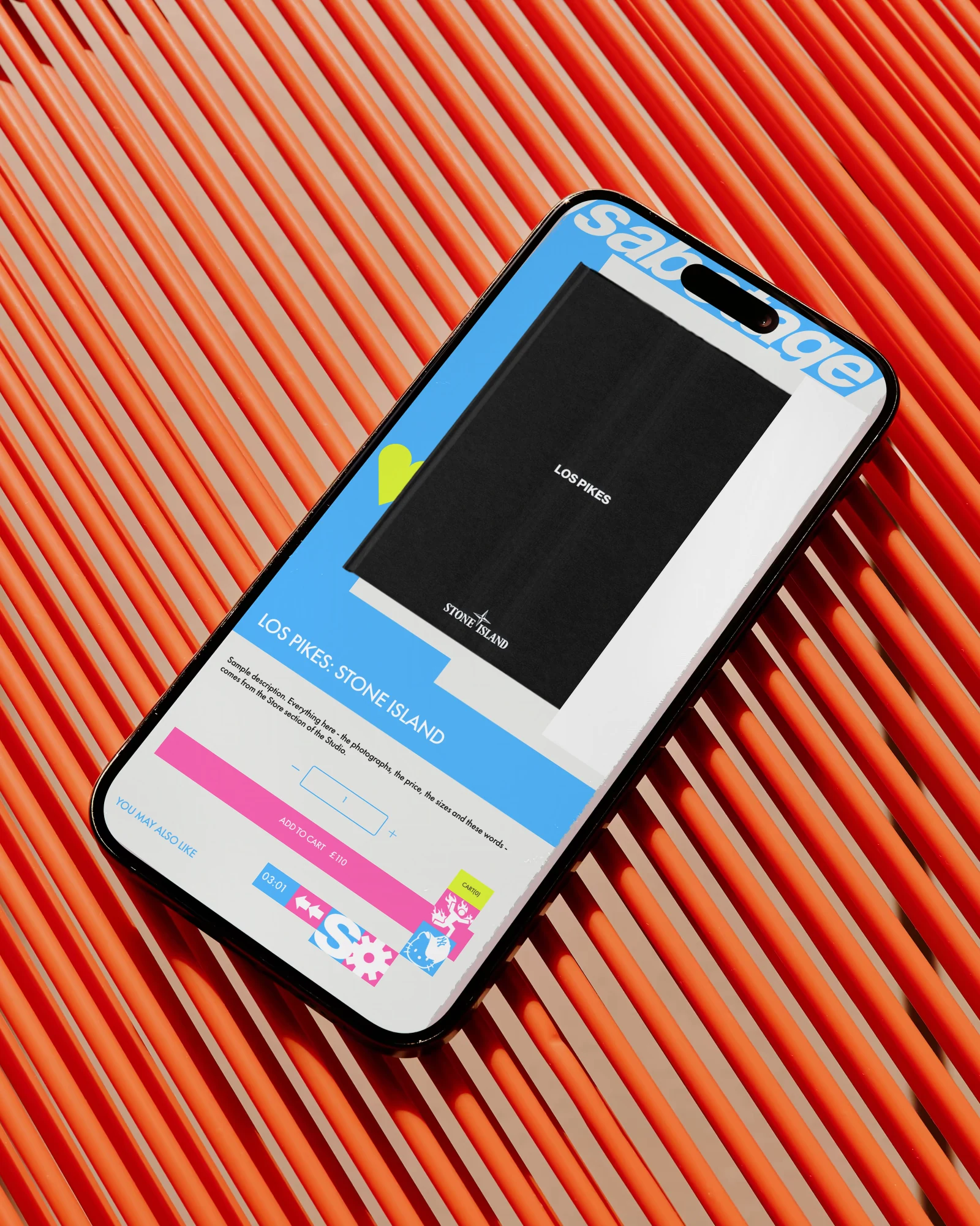 A Sabotage product page on an iPhone lying on an orange cord chair: the Los Pikes book on blue and a pink Add to cart bar