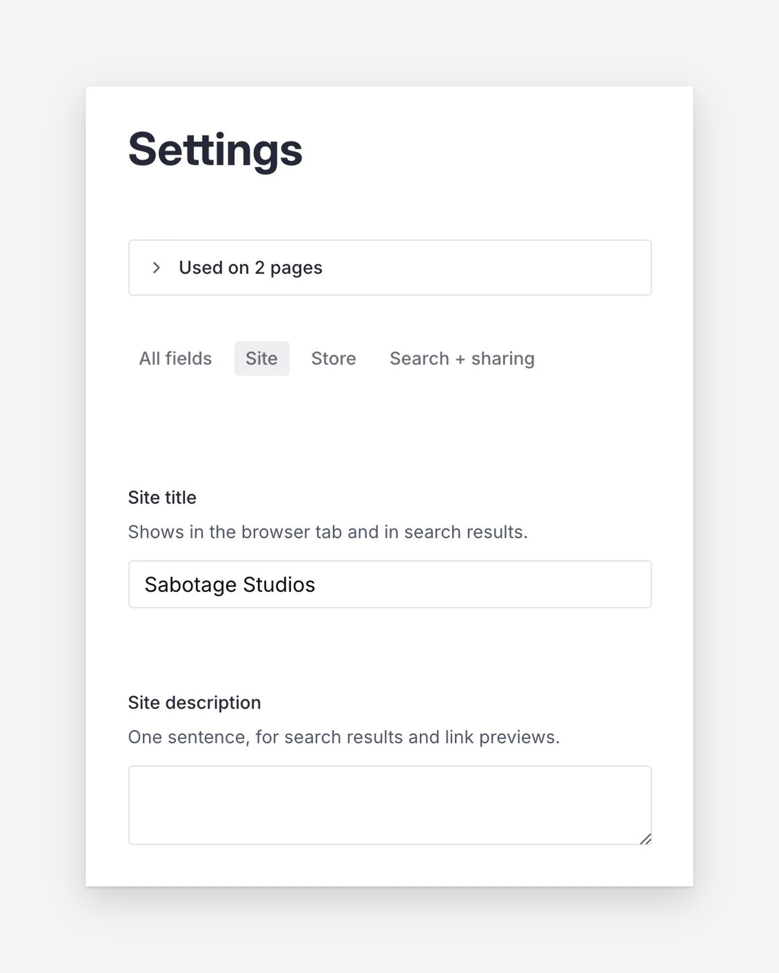 The Settings document in the Sabotage Studio, set on paper: the Site, Store and Search + sharing tabs over the site title and description fields