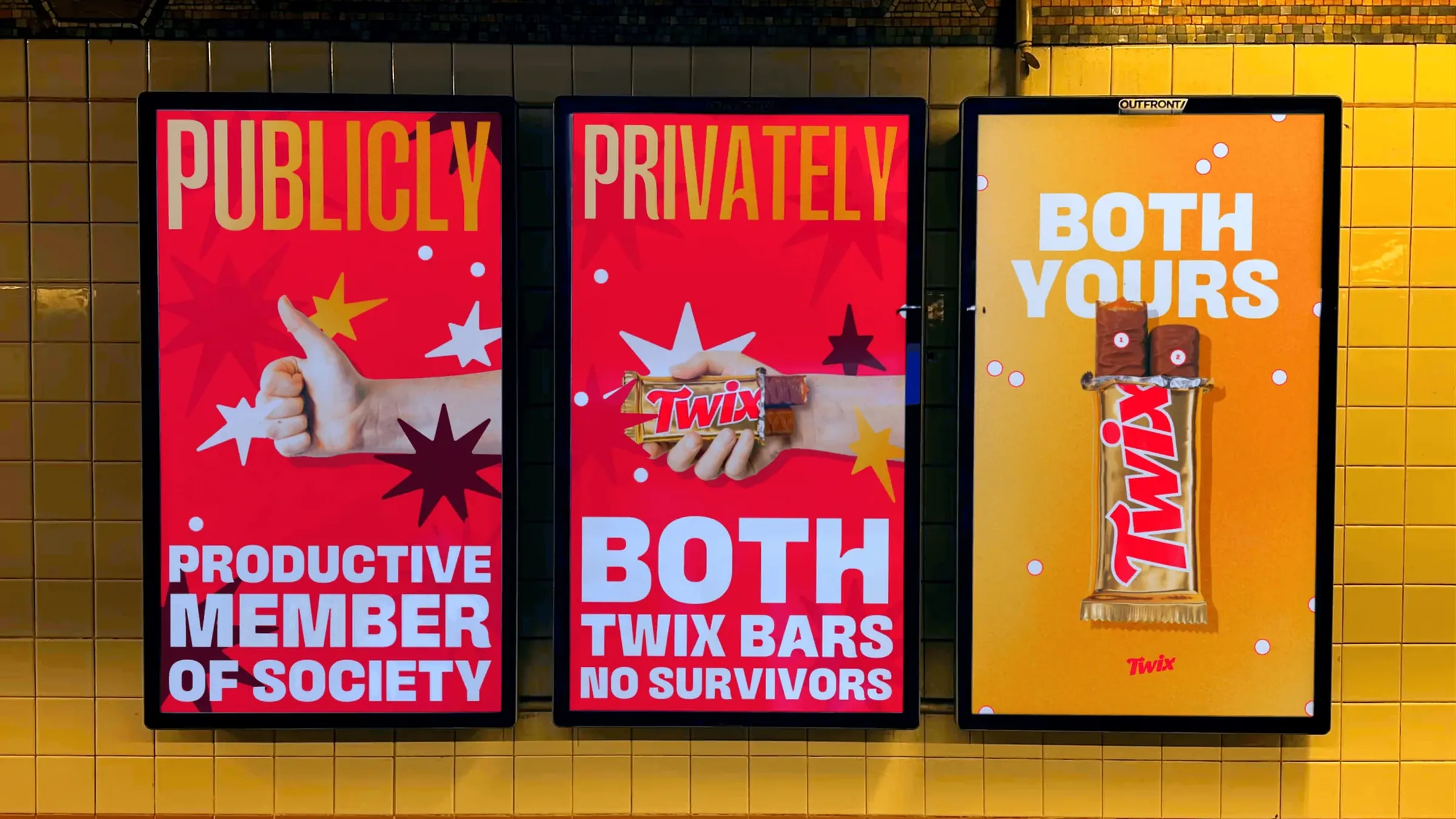 Three digital subway screens on yellow tile: PUBLICLY PRODUCTIVE MEMBER OF SOCIETY, PRIVATELY BOTH TWIX BARS NO SURVIVORS, and BOTH YOURS