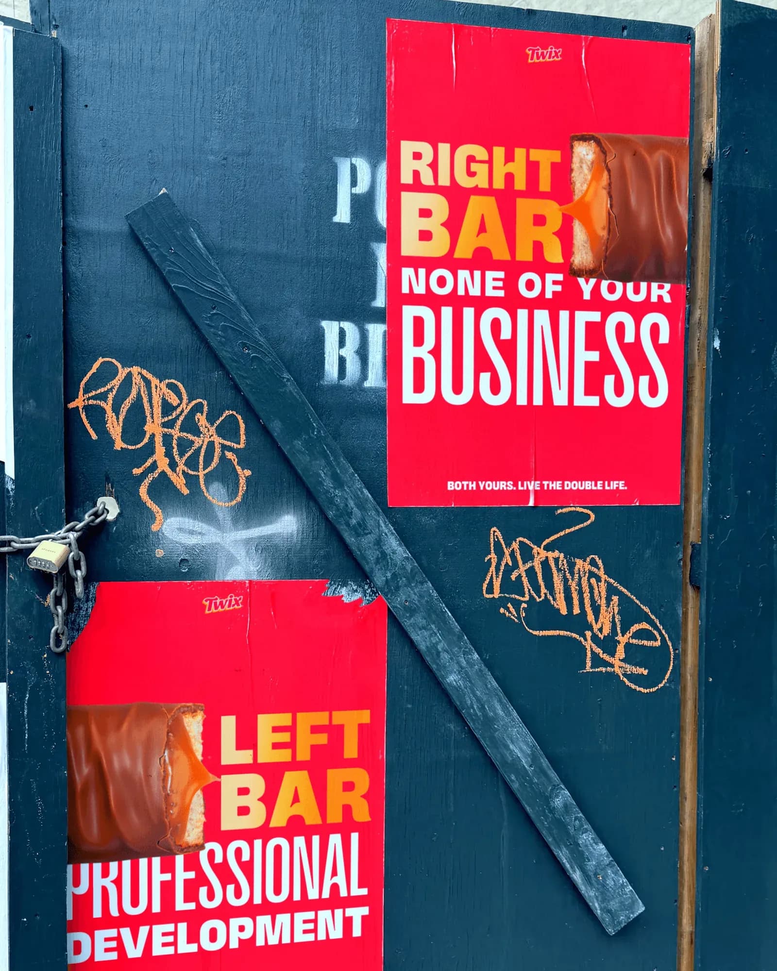 Red wheat-paste posters on a dark hoarding: RIGHT BAR, NONE OF YOUR BUSINESS and LEFT BAR, PROFESSIONAL DEVELOPMENT