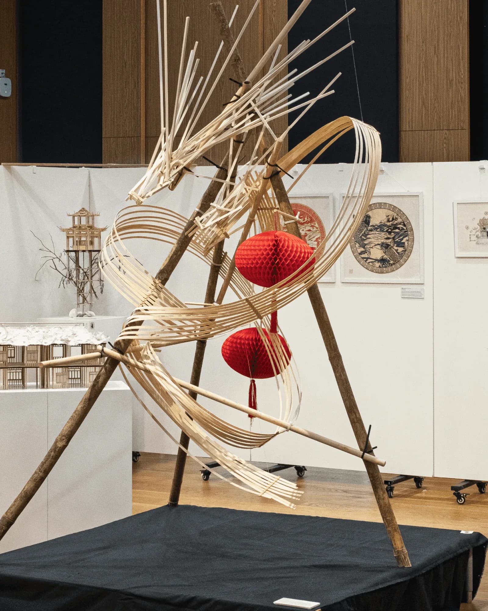 魚躍龍門 Metamorphosis, March 2025, bamboo and balsa, 150 × 150 × 230 cm: the dragon on its black plinth with red lanterns
