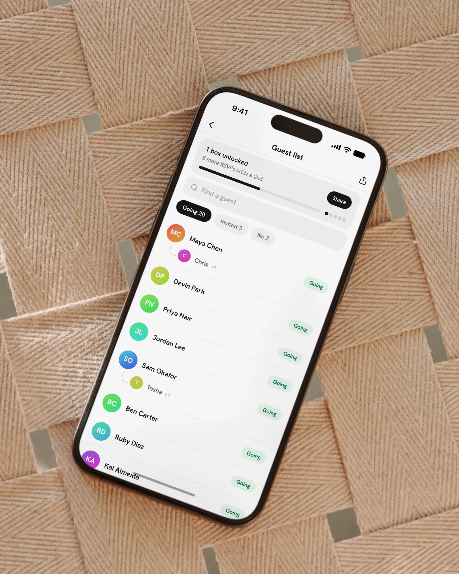 An iPhone on woven tan leather showing the guest list, with the perk meter over the guests marked Going