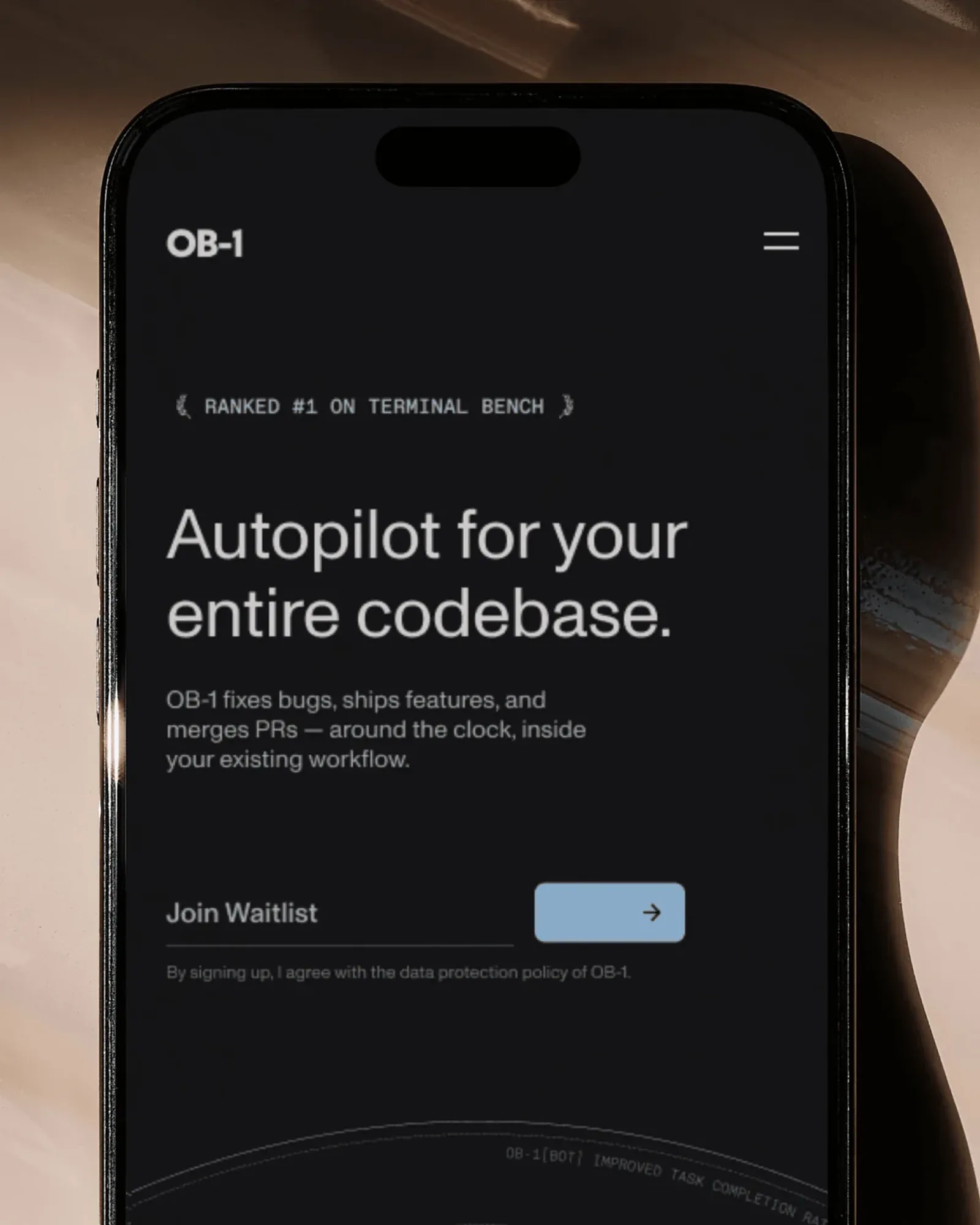 An iPhone on a glossy beige surface showing the OB-1 mobile site: Ranked #1 on Terminal Bench, Autopilot for your entire codebase, and a Join Waitlist field
